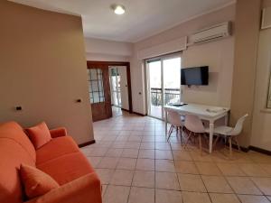 a living room with a couch and a table at LAMEZIA AIRPORT APPARTMENT. in SantʼEufemia Lamezia