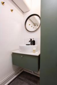 uma casa de banho com um lavatório e um espelho em Amazing studio 2P - Buttes Chaumont em Paris