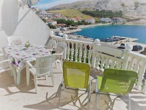 a table and chairs on a balcony with a view of the water at Apartments Niko Metajna, island Pag in Metajna