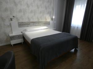 una camera con un grande letto e una finestra di Hotel Vivar a Griñón