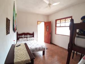 a bedroom with a bed and a ceiling fan at Pousada Natureza in São Thomé das Letras