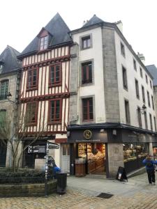 a building on the corner of a street with a store at Spacieux T3 en hyper centre in Quimper +11 photos
