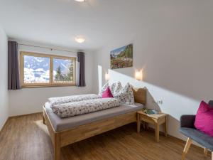 een slaapkamer met een bed met roze kussens en een raam bij Apart Verena in Ramsau im Zillertal