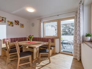 een eetkamer met een tafel en stoelen en een raam bij Apart Verena in Ramsau im Zillertal