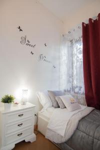 ein Schlafzimmer mit einem Bett mit einer weißen Kommode und Worten an der Wand in der Unterkunft Casa degli Orti, Dolomia best home in Trient