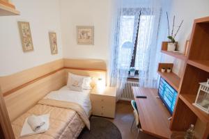 ein kleines Schlafzimmer mit einem Bett und einem Schreibtisch in der Unterkunft Casa degli Orti, Dolomia best home in Trient
