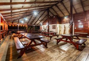 Habitación grande con mesas y bancos de madera. en La Anita Rain Forest en Colonia Dos Ríos