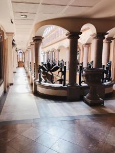 a hallway in a building with columns and a statue at Hotel Casa de los Angel's in San Juan de los Lagos