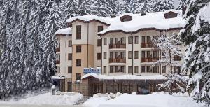 un edificio cubierto de nieve con árboles nevados en Enjoy Studio and Lovely Apartment Villa Park, en Borovets