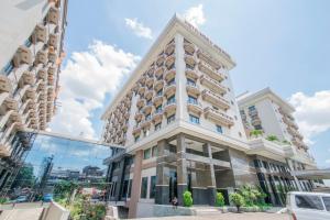 a tall white building with a lot of windows at Mega Anggrek Hotel Jakarta Slipi in Jakarta