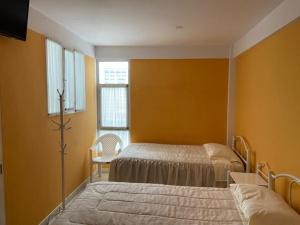 een slaapkamer met 2 bedden en een raam bij Hostal CASABLANCA in Oruro