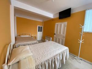 sypialnia z 2 łóżkami i telewizorem z płaskim ekranem w obiekcie Hostal CASABLANCA w mieście Oruro