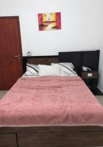 a bedroom with a large bed with a red blanket at Villa Maior Hotel in São Roque