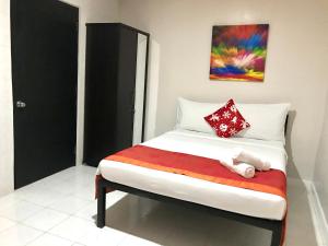 1 cama en una habitación con un cuadro en la pared en HalfWay House Hostel Mactan Cebu Airport en Isla de Mactán