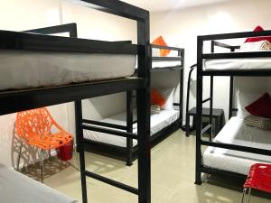 a room with four bunk beds and a chair at HalfWay House Hostel Mactan Cebu Airport in Mactan