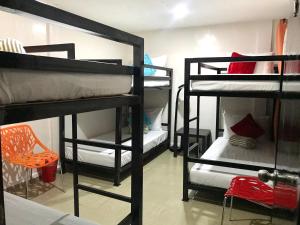Zimmer mit 4 Etagenbetten und einem Stuhl in der Unterkunft HalfWay House Hostel Mactan Cebu Airport in Mactan