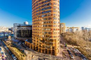 a tall yellow building in a city with parked cars at 2к квартира у новому будинку на 10 поверсі, Печерськ in Kyiv