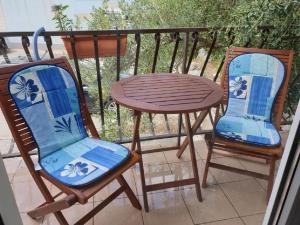 two chairs and a table on a balcony at Apartments Nina - private parking in Seget Vranjica