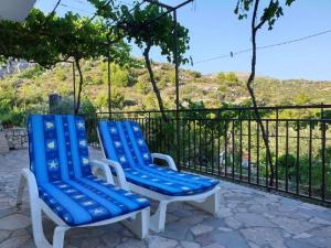 twee blauwe en witte stoelen op een patio bij Apartments Nina - free private parking in Seget Vranjica