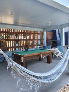 a hammock in a room with a pool table at POUSADA MORADAS DO JAU in Hermenegildo
