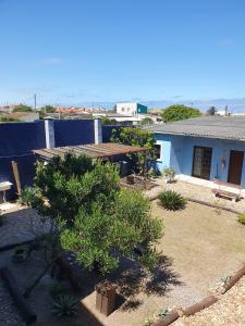 a yard with trees and a blue house at POUSADA MORADAS DO JAU in Hermenegildo