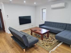 a living room with two couches and a coffee table at Brand New Home - Central Masterton in Masterton