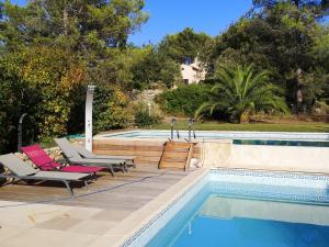 a swimming pool with two lounge chairs next to a swimming pool at Gorgeous Villa in Bagnols en For t in Bagnols-en-Forêt