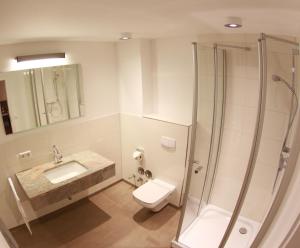 a bathroom with a shower and a toilet and a sink at Hotel-Restaurant Entrada in Bielefeld