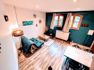 貝萊的住宿－La Maison cachée du PAVILLON BELLEVUE，客厅配有蓝色的沙发和桌子