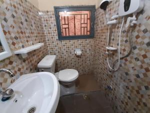 a bathroom with a sink and a toilet and a window at Villa Chambre C climatisée douche Cuisine salon in Bamako