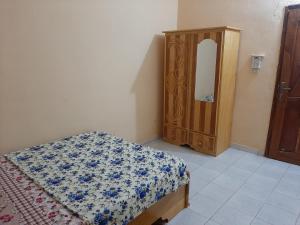 1 dormitorio con cama y tocador de madera en Villa Chambre C climatisée douche Cuisine salon en Bamako