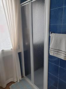 a shower with a glass door in a bathroom at GRAZIOSA BIFAMILIARE AD ASIAGO con giardino privato in Asiago +36 photos