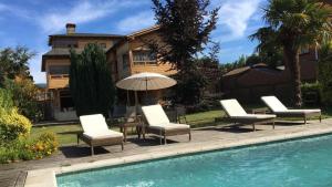 a group of chairs and an umbrella next to a pool at B&B de German in Pucón