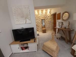 a living room with a flat screen tv on a wall at Palazzino d Irene in Rethymno Town