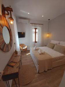 a bedroom with a large bed and a mirror at Palazzino d Irene in Rethymno Town