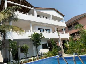 a villa with a swimming pool in front of a building at Villa Luxury Baguida in Lomé