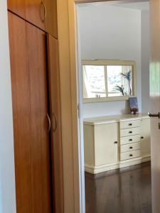 a bedroom with a dresser and a mirror at Rosenhaus - HomeClub apto grande com Smartv cozinha piscina in Joinville