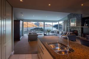 a kitchen with a sink and a living room at 13 Poole Lane by Staysouth in Queenstown