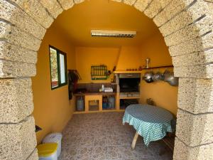 a kitchen with an archway and a table in a room at Casa Rural La Sombrera in Fasnia
