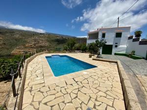 a swimming pool in front of a house at Casa Rural La Sombrera in Fasnia