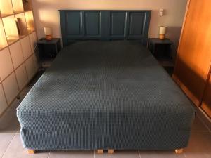 a large black bed in a room with two tables at Beautiful Ground Floor, Seaside Studio Flat in Le Moule