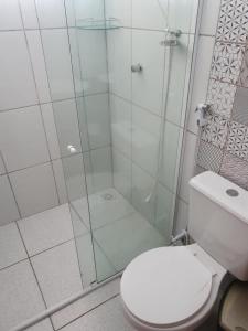 La salle de bains est pourvue de toilettes et d'une douche en verre. dans l'établissement Pousada Luz - Santo Amaro do Maranhão, à Santo Amaro