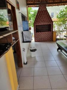 a living room with a brick fireplace and a table at Pousada Luz - Santo Amaro do Maranhão in Santo Amaro