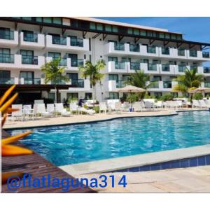 a swimming pool in front of a hotel at Laguna Beach Flat 314- Porto de Galinhas in Porto De Galinhas