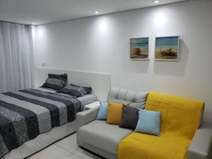 a bedroom with a bed and a couch and a bed at Laguna Beach Flat 314- Porto de Galinhas in Porto De Galinhas +15 photos