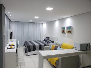 a living room with a couch and a bed in it at Laguna Beach Flat 314- Porto de Galinhas in Porto De Galinhas