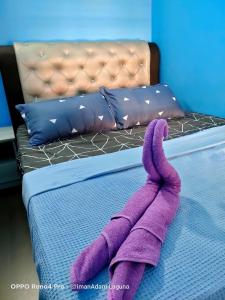a purple towel is laying on a bed at imanAdam Laguna Apartment in Port Dickson