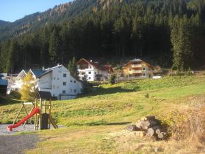 park z placem zabaw na wzgórzu z domami w obiekcie Apart Alcazar w mieście Ischgl