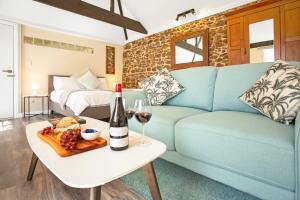 Sala de estar con sofá azul y botella de vino en Settlers Cottage en McLaren Vale