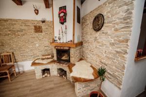 a living room with a stone fireplace with two cats sleeping in it at Casa Cristalul Muntilor in Poiana Mărului